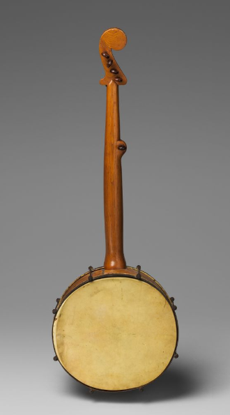 This banjo has a wide, round base with a decorative neck with tuning pegs.