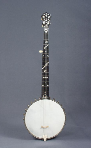 This banjo has a white, round base with a black and silver decorative neck with frets, strings, and tuning pegs.