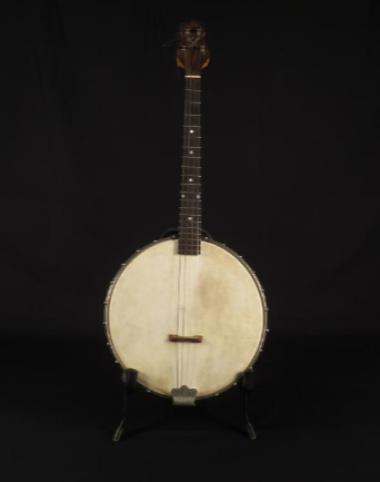 This banjo has a wide, round base with a short neck with frets, tuning pegs, and strings.