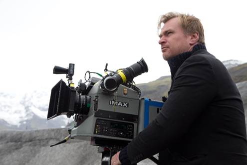 Christopher Nolan outside near mountains handling an IMAX camera